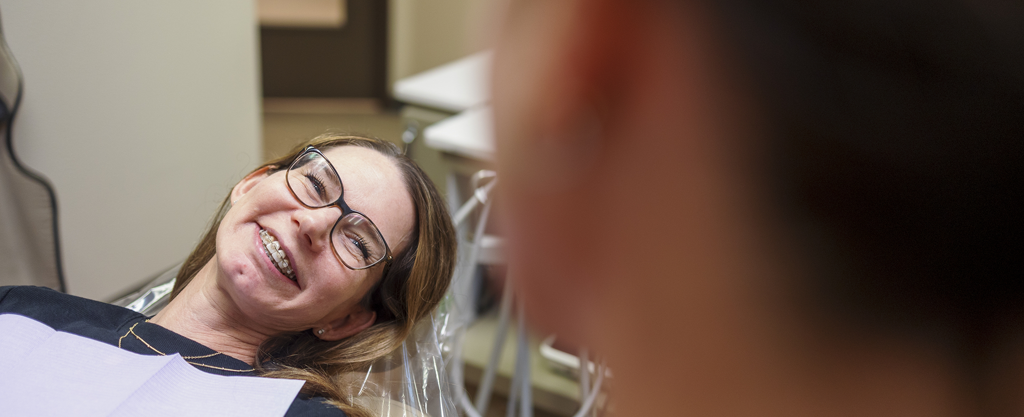 Young woman in the dental chair grinning