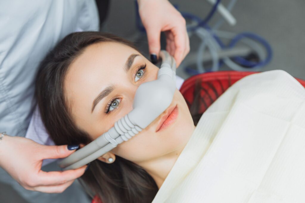 Dentist placing nitrous oxide mask over patient's nose