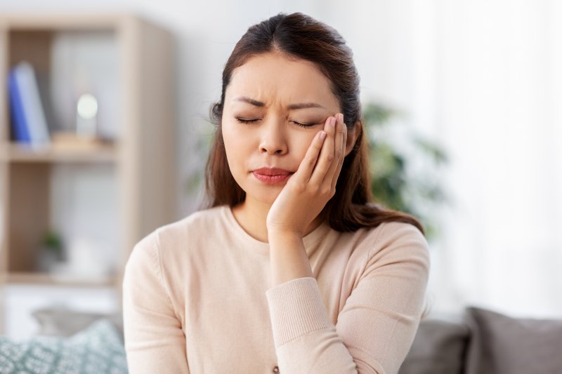 An upset woman experiencing one of the types of tooth pain